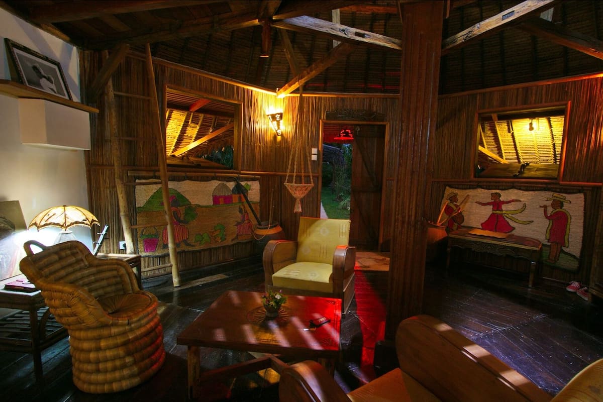 A rustic interior with wooden walls, a thatched roof, and traditional decor.