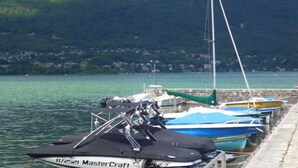 A marina with several boats docked along a stone pier. - Weekend Hotel Les Pieds dans l'Eau (Viviers-du-Lac)