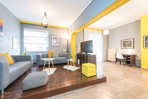 Relax in this stylish living room with a sofa, ottoman, and desk, perfect for unwinding.