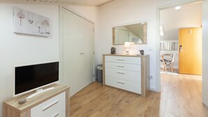 A modern bedroom with a flat-screen TV, a wooden dresser, a large mirror, and a door labeled '3'. - Avenida apartement (Braga)
