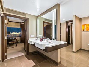 A modern bathroom with two sinks, a large mirror, and a view of a cityscape through a window. - Secret Suites at Vdara (Las Vegas)