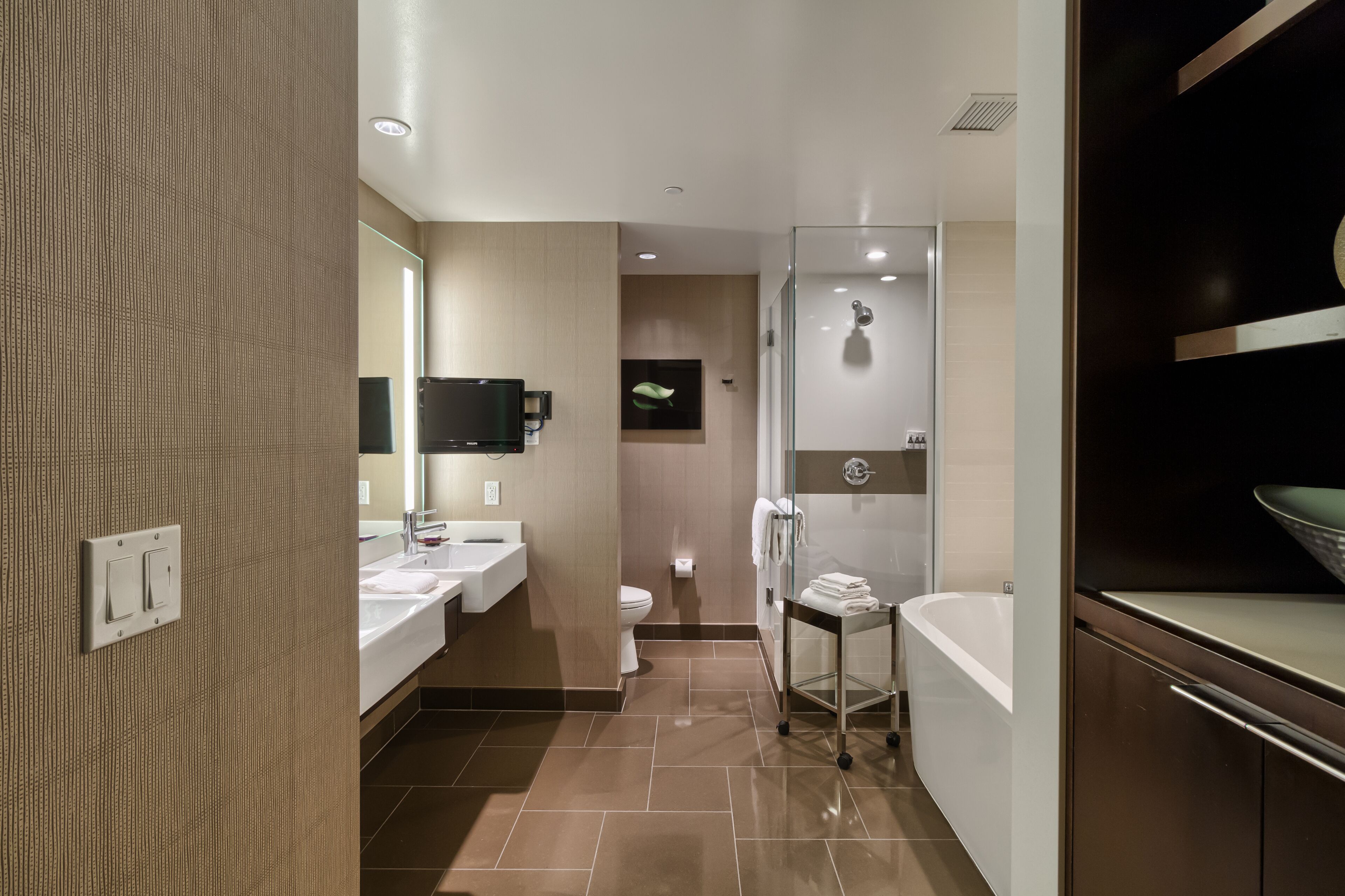 Une salle de bain moderne dotée d’une douche à parois de verre, d’une baignoire et d’un meuble-lavabo avec un miroir.