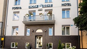 A hotel with a modern facade, balconies with flower pots, and a well-maintained entrance area. - Nota Bene Loft (Lviv)