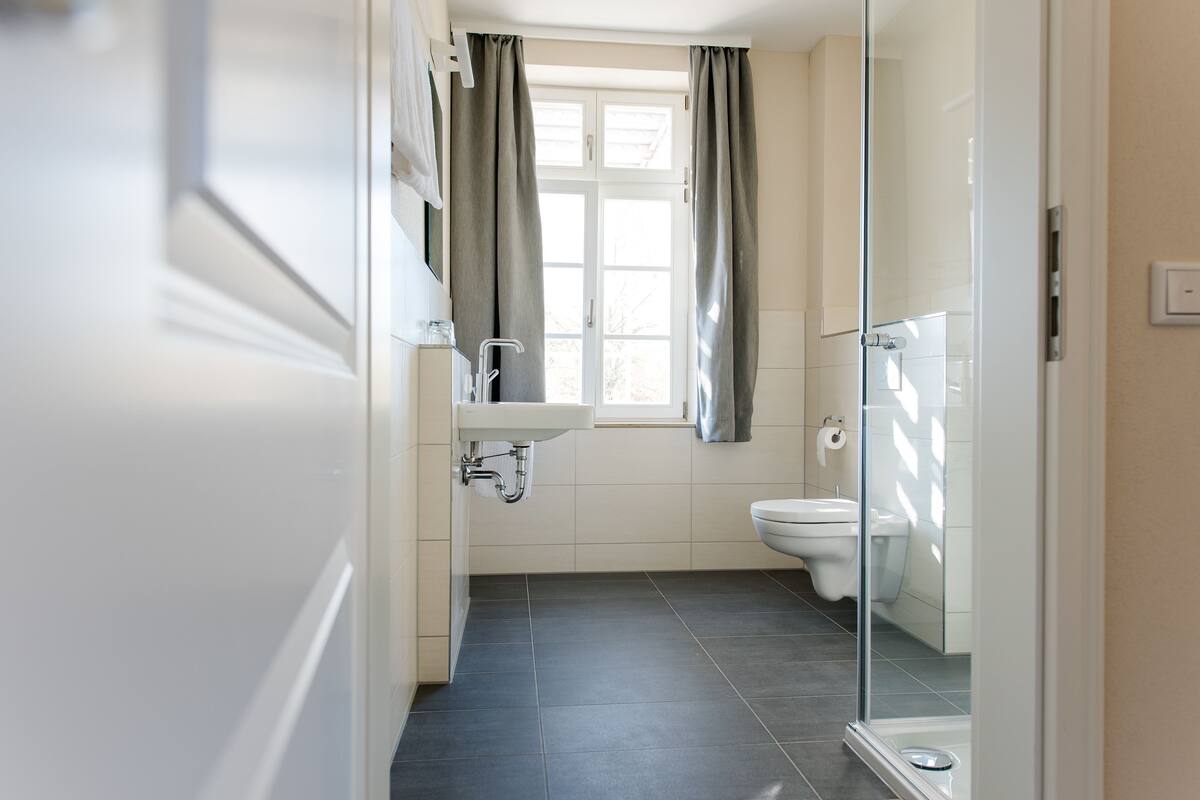 Ein Badezimmer mit Toilette, Waschbecken und Duschbereich.