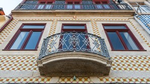 En bygning med en dekoreret balkon, mange vinduer og mønstret flisearbejde.