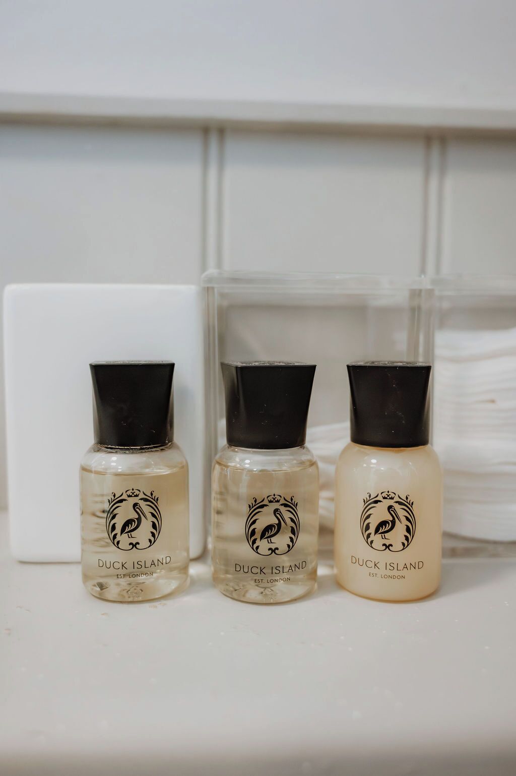 Tres botellas de Duck Island Est. London sobre una superficie blanca.