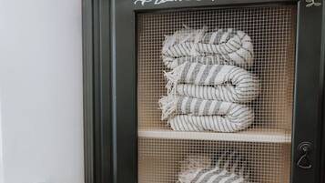 Una vitrina con el texto 'BEACH TOWELS' y dos estantes llenos de toallas a rayas.