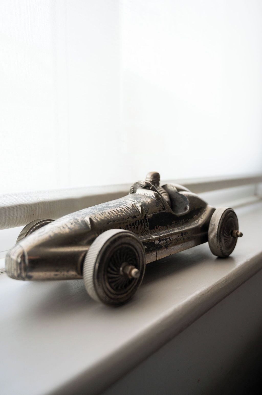 Un modelo de coche antiguo sobre un alféizar.