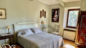 Een slaapkamer met een bed, een radiator, een raam en een deur.