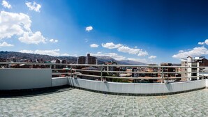 A rooftop terrace with a view of a cityscape and mountains. - Yuyay Apartaments Cusco (Cusco)
