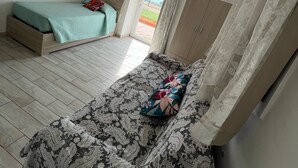 Una habitación con dos camas, un armario y una ventana con vistas.