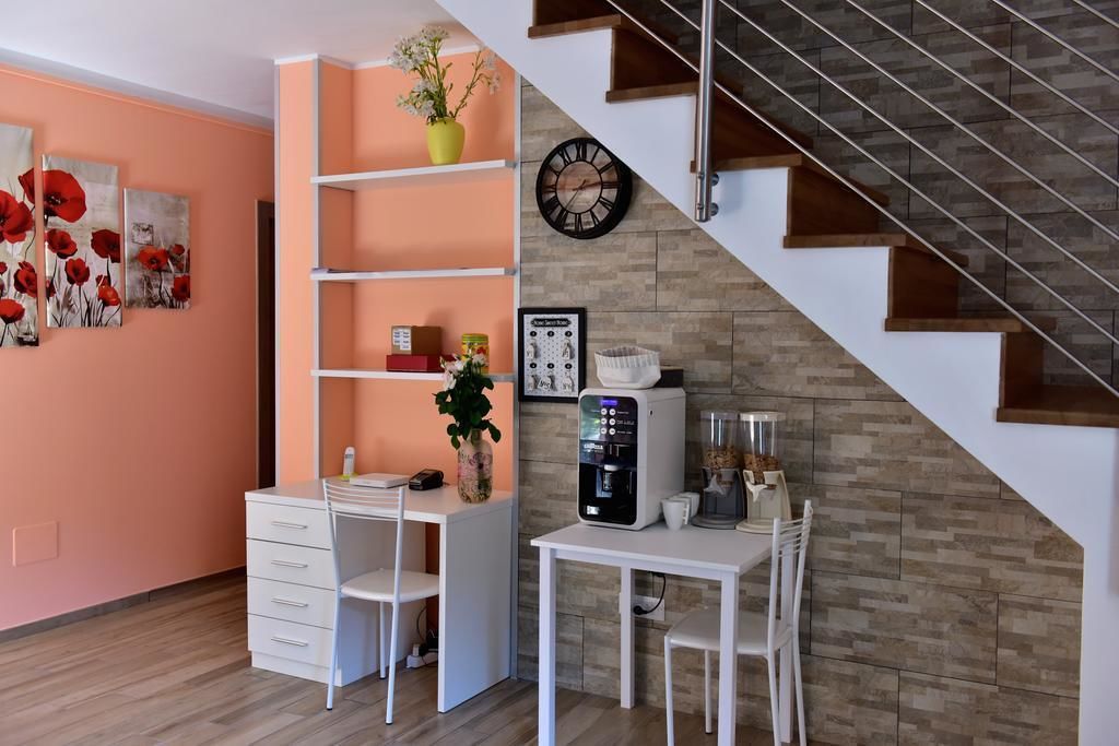 A modern kitchen with white cabinetry, a built-in coffee machine, and a staircase leading to an upper level.