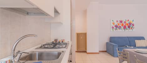 Une cuisine moderne équipée d’un évier, d’une cuisinière et d’un coin repas avec des chaises et une table.