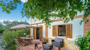 An outdoor patio with a table and chairs, a sofa, and a potted plant. - Agriturismo Tontenano (Bucine)