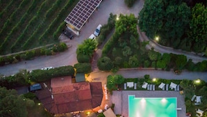 An aerial view of a property with a swimming pool, a covered patio area, and a solar panel installation. - Agriturismo Tontenano (Bucine)