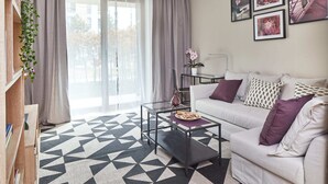 Een moderne woonkamer met een bank, salontafel en een vloerkleed met een geometrisch patroon.
