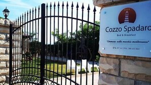 A gated entrance with a sign for "Cozzo Spadarco Bed & Breakfast" and a stone wall. - Cozzo Spadaro B&B (Pachino)