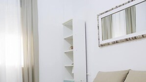 A hotel room with a bed, a wardrobe, and a mirror on the wall. - Cozzo Spadaro B&B (Pachino)