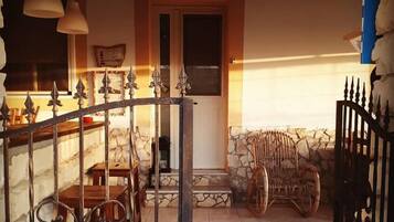 Un interno rustico con camino in pietra, mobili in legno e un cancello in ferro battuto.