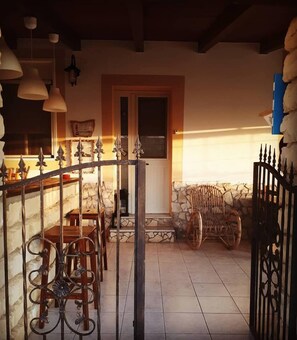 A rustic interior with a stone fireplace, wooden furniture, and a wrought iron gate. - Cozzo Spadaro B&B (Pachino)