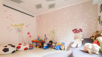 Playful space for kids with toys, a table, and a rocking chair.