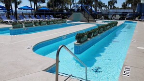 A swimming pool with multiple lanes, marked depth indicators, and lounge chairs. - Boardwalk 932 (Myrtle Beach)