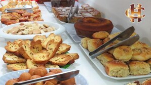 A buffet table with various baked goods including bread, biscuits, and rolls. - Hotel Centenário (Juiz de Fora)