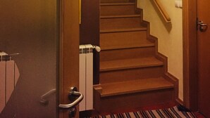 Een trap naar een bovenverdieping, een deur met de tekst 'FONTE' en een bordje dat een toilet aangeeft.