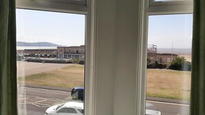 Vista a través de una ventana con cielo despejado, un estacionamiento y un edificio con un letrero que dice "TELECOM".