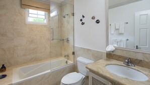 A bathroom with a bathtub, toilet, sink, and a large mirror. - Blue Haven (Bowling Alley Hill)