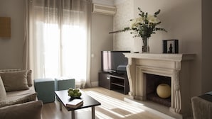 A living room with a fireplace, a television, and a sofa. - Hostal Goya (Barcelona)