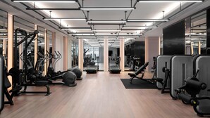A modern gym with exercise equipment, mirrored walls, and a wooden floor. - Courtyard by Marriott Shanghai Minhang (Shanghai)