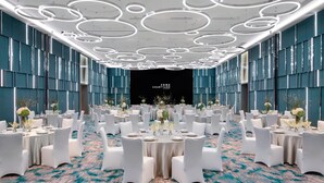 A banquet hall with round tables, white chairs, and a blue carpet. - Courtyard by Marriott Shanghai Minhang (Shanghai)