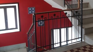 A staircase with red walls and a checkered floor. - Antico Palazzo (Piazza Armerina)