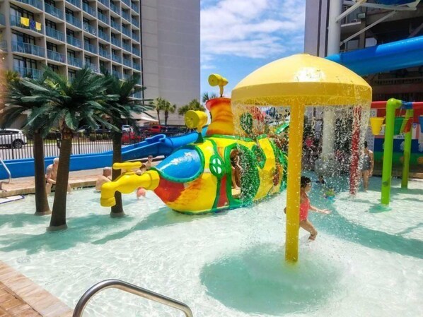 A water park with a colorful water slide and a large water fountain. - Long Bay 216 (Myrtle Beach)
