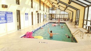 Sisätiloissa sijaitseva uima-allas, jossa on selkeät opasteet, mukaan lukien kyltti, jossa lukee «Hyppääminen kielletty», ja varoitusmerkki, jossa lukee «Matala vesi».