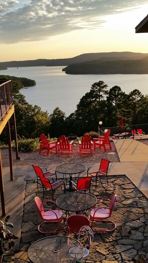 Outdoor seating with tables and chairs, overlooking a body of water and hills. - Pointe West Resort  (Eureka Springs)