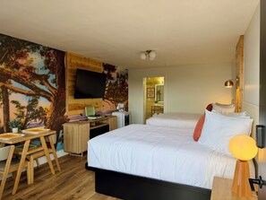 A hotel room with a bed, desk, and a wall-mounted TV. - Pointe West Resort  (Eureka Springs)
