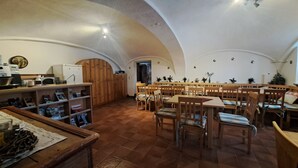 A spacious dining area with wooden furniture and a high arched ceiling. - Vacation apartment no. 1 (Neuötting)