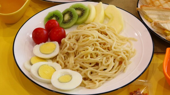 A plate of spaghetti with cherry tomatoes, kiwi slices, banana slices, and hard-boiled eggs. - Full Moon Resort (Hengchun)