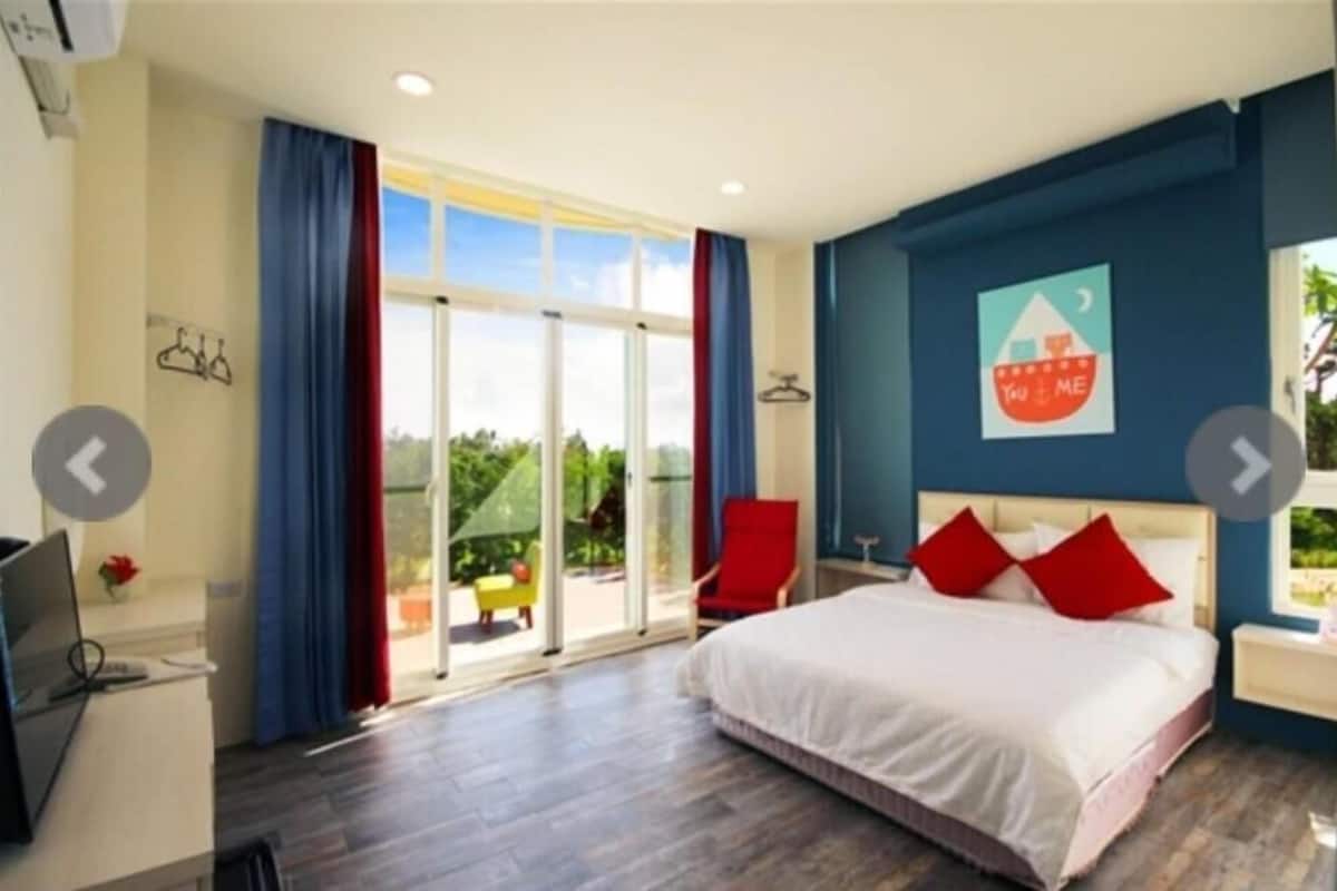 A bedroom with a bed, a desk, and a chair.