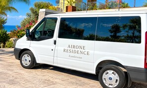 Una camioneta blanca con la leyenda 'AIRONE RESIDENCE' y 'Zambrone' escrita en la carrocería.