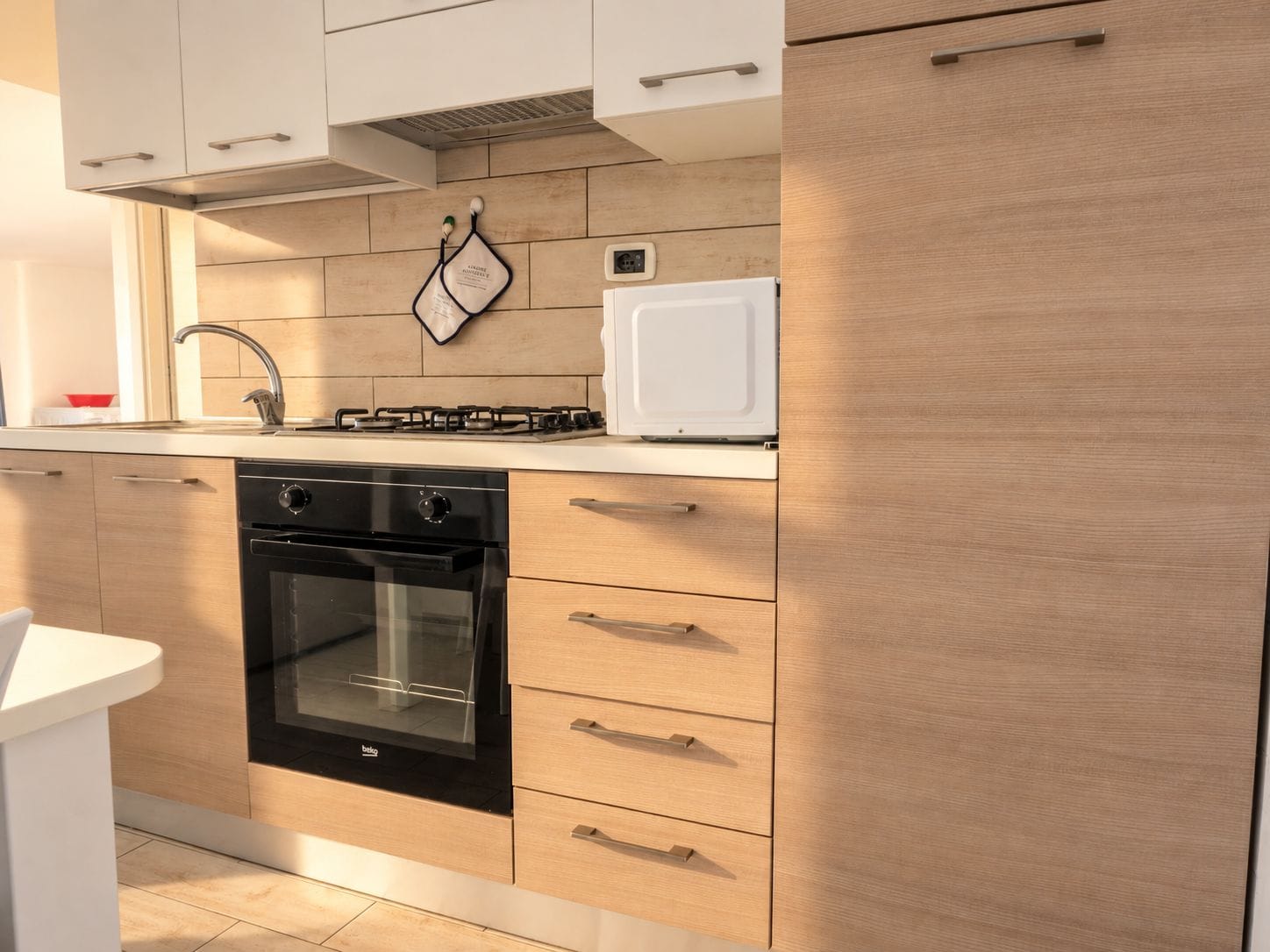 A modern kitchen with a built-in oven, a stove, and a microwave.