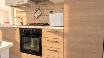 A modern kitchen with a built-in oven, a stove, and a microwave.