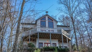 A two-story house with a balcony, surrounded by trees. - Captain Morley`s Mountain Inn (Morganton)
