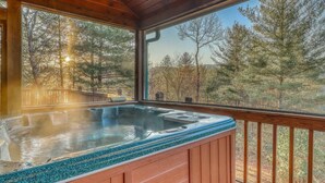 A hot tub in a wooden cabin with a view of a forest. - Paradise Lodge (Blue Ridge)