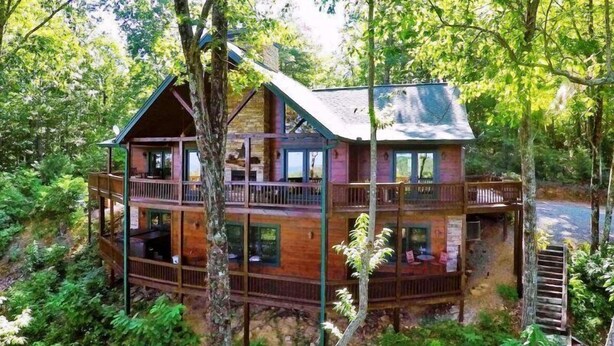 A multi-story cabin with a balcony, surrounded by dense forest. - Another Day In Bearadise (Blue Ridge)