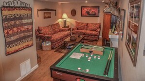 A cozy living room with a pool table, two patterned sofas, a lamp, and a moose head decoration. - Tranquilidad (Blue Ridge)