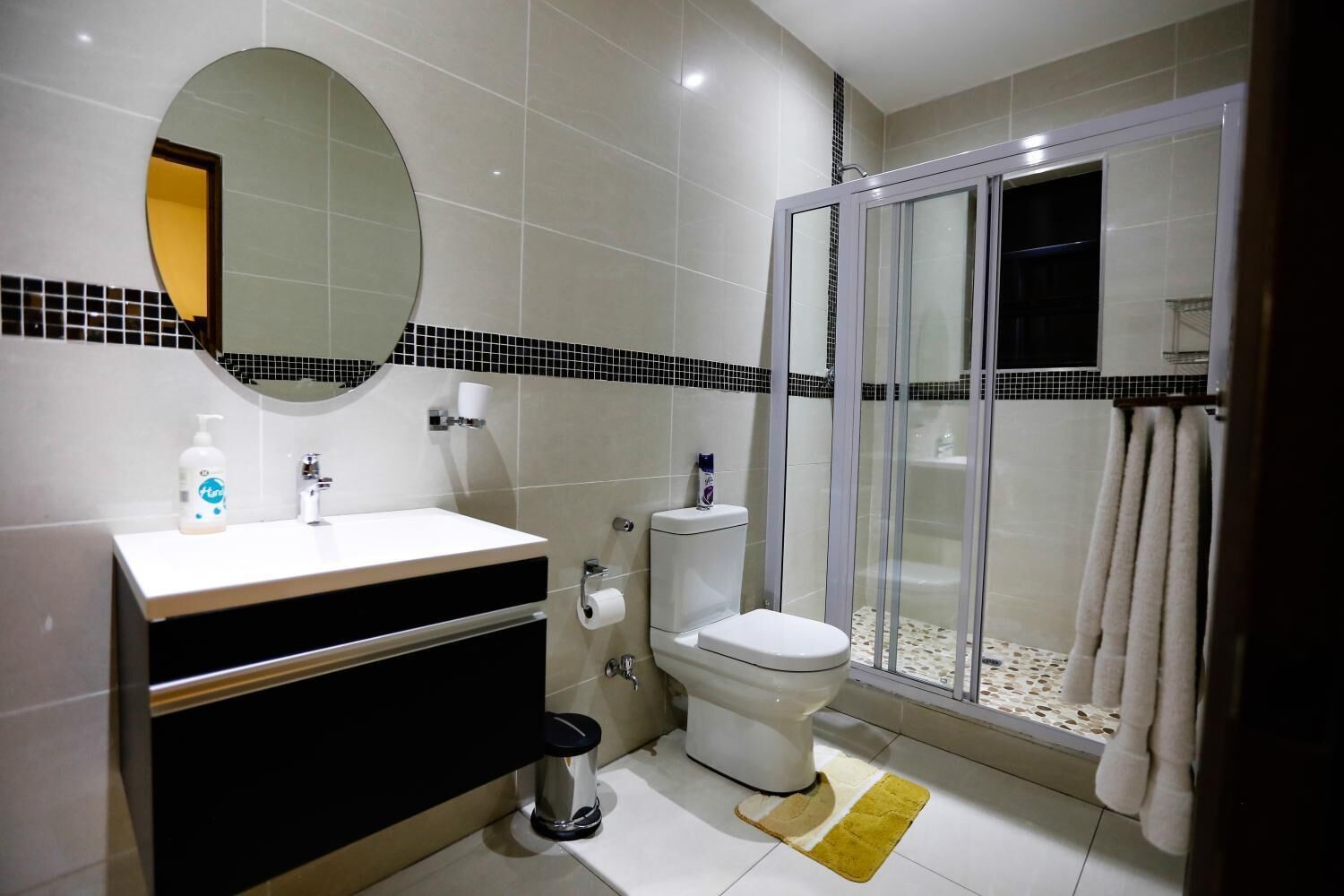 A modern bathroom with a toilet, sink, and shower area.