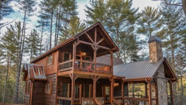 A rustic cabin with a wooden exterior, a stone chimney, and a balcony. - Miss Celies Cabin (Blue Ridge)